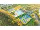 Aerial view of community pool, tennis courts, basketball, and lush landscaping at 3339 Brenford Pl, Land O Lakes, FL 34638