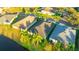 An aerial view showcases backyards with well-manicured lawns, mature palm trees and a serene pond at 3339 Brenford Pl, Land O Lakes, FL 34638