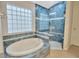 Bathroom featuring a tiled soaking tub, glass block window, and enclosed shower at 3339 Brenford Pl, Land O Lakes, FL 34638