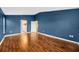 Spacious primary bedroom featuring hardwood floors and tranquil blue walls at 3339 Brenford Pl, Land O Lakes, FL 34638