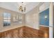 Bedroom with hardwood floors and natural light from three large windows at 3339 Brenford Pl, Land O Lakes, FL 34638