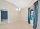 Cozy dining area with tile floors, modern chandelier, and serene outdoor view through the window at 3339 Brenford Pl, Land O Lakes, FL 34638