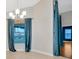Well-lit dining area with a chandelier, neutral walls, and a view of the outdoors through the window at 3339 Brenford Pl, Land O Lakes, FL 34638