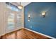 Bright foyer showcasing hardwood flooring, a stylish light fixture, and a charming, colored accent wall at 3339 Brenford Pl, Land O Lakes, FL 34638
