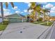 Inviting curb appeal with a wide driveway and mature palm trees enhancing this home's facade at 3339 Brenford Pl, Land O Lakes, FL 34638