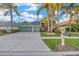 Charming home with a well-manicured lawn, palm trees, and a spacious driveway leading to a two-car garage at 3339 Brenford Pl, Land O Lakes, FL 34638