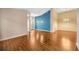 Open floorplan living room with wood floors, transom window, and lighting at 3339 Brenford Pl, Land O Lakes, FL 34638