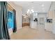 Open concept living space with tile flooring, kitchen bar, chandelier, and a lovely window view at 3339 Brenford Pl, Land O Lakes, FL 34638