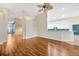 Open living space showcasing hardwood floors connecting living room to kitchen with modern appliances at 3339 Brenford Pl, Land O Lakes, FL 34638