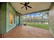 Screened-in patio showcasing brick flooring, ceiling fan, and peaceful view of the waterfront at 3339 Brenford Pl, Land O Lakes, FL 34638