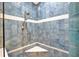 Shower with blue tiling and corner seat at 3339 Brenford Pl, Land O Lakes, FL 34638