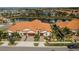 Aerial view of homes with tile roofs near a community pond and lush green spaces at 5316 Stoic Vale Dr, Wimauma, FL 33598
