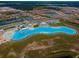 High angle view of community lagoon, beach, cabanas and inflatable obstacle course at 5316 Stoic Vale Dr, Wimauma, FL 33598