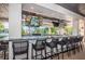 Outdoor bar area with multiple TVs, comfortable seating, and a view of the pool at 5316 Stoic Vale Dr, Wimauma, FL 33598