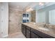 Bathroom features a double sink vanity with granite countertops and tiled walk-in shower at 5316 Stoic Vale Dr, Wimauma, FL 33598