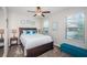 A charming bedroom features a queen size bed, bedside tables, and a sunny window at 5316 Stoic Vale Dr, Wimauma, FL 33598