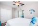 Bright bedroom with a ceiling fan, a white bed, and a view of a sitting room at 5316 Stoic Vale Dr, Wimauma, FL 33598