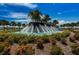The community fountain is surrounded by colorful landscaping and stately palm trees at 5316 Stoic Vale Dr, Wimauma, FL 33598
