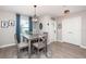 Charming dining area with a modern light fixture, wood-look flooring, and blue curtains provides a cozy atmosphere at 5316 Stoic Vale Dr, Wimauma, FL 33598