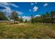 A grassy dog park with trees and benches offers a spacious area for pets and their owners at 5316 Stoic Vale Dr, Wimauma, FL 33598