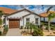 Inviting single-story home with a terracotta roof, lush landscaping, and a spacious two-car garage at 5316 Stoic Vale Dr, Wimauma, FL 33598