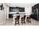 Modern kitchen with dark cabinets, stainless steel appliances, an island with counter seating creates a culinary haven at 5316 Stoic Vale Dr, Wimauma, FL 33598