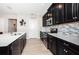 Sleek kitchen featuring dark cabinetry, stainless steel appliances, and a mosaic backsplash offers a stylish cooking space at 5316 Stoic Vale Dr, Wimauma, FL 33598