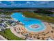 Aerial view of the community lagoon, with inflatable obstacle course, beach, and lounge area at 5316 Stoic Vale Dr, Wimauma, FL 33598