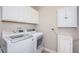 Bright laundry room includes a front loading washer and dryer and white cabinets at 5316 Stoic Vale Dr, Wimauma, FL 33598