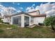 Rear exterior showcasing the screened lanai, tile roof, and well-maintained landscaping at 5316 Stoic Vale Dr, Wimauma, FL 33598
