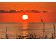 A stunning sunset over the ocean, casting an orange glow on the water and sky at 555 Gulf Way # 7N, St Pete Beach, FL 33706