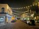 Charming streetscape illuminated by festive string lights, showcasing shops, restaurants, and the town's inviting ambiance at 555 Gulf Way # 7N, St Pete Beach, FL 33706