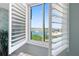 A window with open shutters reveals a beautiful water view with a fountain in the distance at 6287 Bahia Del Mar Cir # 606, St Petersburg, FL 33715