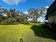 Expansive backyard featuring a large tree, green lawn, and blue skies at 7040 Cognac Dr # 1, New Port Richey, FL 34653
