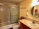 Cozy bathroom featuring a vanity with sink, toilet, and a shower/tub combo with decorative sliding doors at 7040 Cognac Dr # 1, New Port Richey, FL 34653