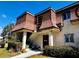 Close-up of a charming two-story townhome with a unique roofline, a private entrance, and lush landscaping at 7040 Cognac Dr # 1, New Port Richey, FL 34653