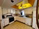 Well-lit kitchen featuring white cabinets, essential appliances, and an efficient layout at 7040 Cognac Dr # 1, New Port Richey, FL 34653