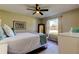 Cozy bedroom with a ceiling fan, natural light from the window and a stylish mirror at 7148 Jenner Ave, New Port Richey, FL 34655