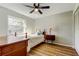 Bedroom featuring a window, ceiling fan, wood floors, a bed and a side table at 7148 Jenner Ave, New Port Richey, FL 34655