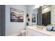 Modern bathroom with white vanity, decorative mirror, and stylish tiles at 8100 Moonbeam Ave, Sarasota, FL 34241