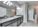 Bathroom featuring dual sinks with granite countertops and a tiled walk-in shower at 10019 Celtic Ash Dr, Ruskin, FL 33573