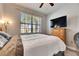 Comfortable bedroom featuring nice window light, modern ceiling fan and a television atop a wooden dresser at 10019 Celtic Ash Dr, Ruskin, FL 33573