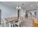 A dining area with a wooden table and white chairs is adjacent to the kitchen at 10019 Celtic Ash Dr, Ruskin, FL 33573