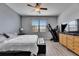 Bright bedroom features a large window, ceiling fan, and modern gray plank flooring at 10019 Celtic Ash Dr, Ruskin, FL 33573