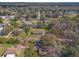 An aerial view shows homes in a wooded neighborhood with mature trees and lush surroundings at 10171 Patrick St, Brooksville, FL 34601