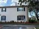 Exterior view of a condominium featuring blue shutters, ample parking, and lush landscaping at 10346 Carrollwood Ln # 171, Tampa, FL 33618