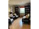 Cozy living room featuring two bookcases, two wicker chairs, sofa, and bright window at 10346 Carrollwood Ln # 171, Tampa, FL 33618