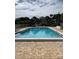 Community pool with tiled deck, lounge chairs and mature landscaping at 10346 Carrollwood Ln # 171, Tampa, FL 33618