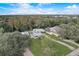 Stunning aerial view of a home with a private pool nestled among lush trees and a long driveway at 11935 Riverhills Dr, Temple Terrace, FL 33617