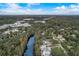 Aerial view showcasing a neighborhood surrounded by lush greenery, with a river running nearby, offering a peaceful setting at 11935 Riverhills Dr, Temple Terrace, FL 33617